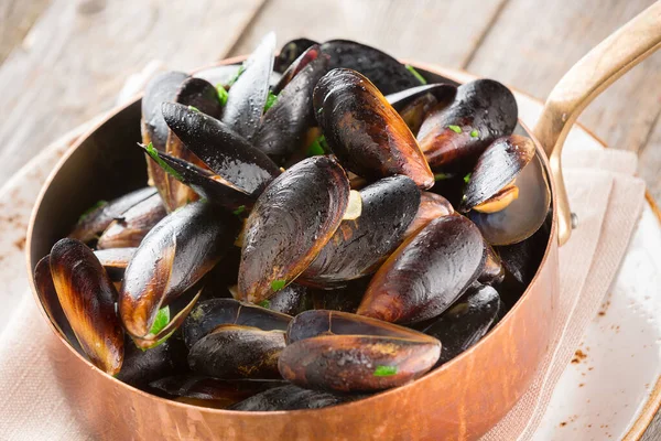 Gekochte Miesmuscheln mit Kräutern in Kupferkochform — Stockfoto