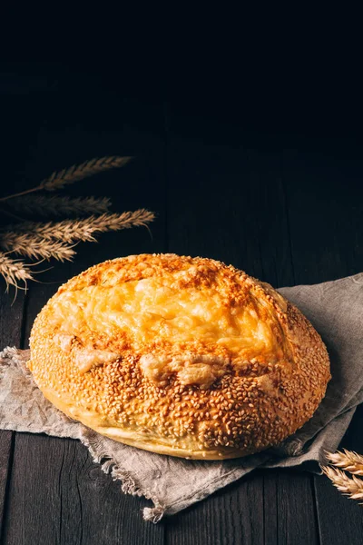 Limpa av vitt bröd med ost på textilhandduk på svart trä bakgrund med kopieringsutrymme — Stockfoto
