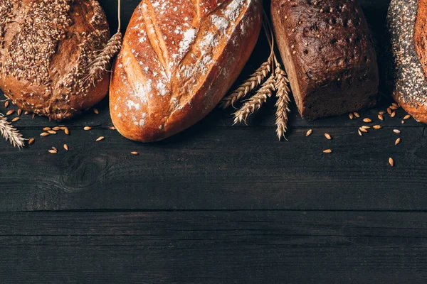 Borde de pan sobre fondo de madera con espacio para copiar. Diferentes tipos de pan dispuestos como marco con espiguillas. Panadería, cocina y concepto de tienda de comestibles . —  Fotos de Stock