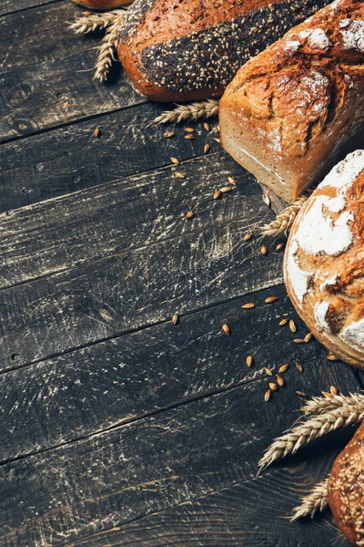 Borde de pan sobre fondo de madera con espacio para copiar. Diferentes tipos de pan dispuestos como marco con espiguillas. Panadería, cocina y concepto de tienda de comestibles . —  Fotos de Stock
