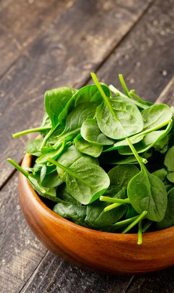 Close-up view of Spinach leafs in Wooden Bowl on wooden background with copy space — Stock Photo, Image