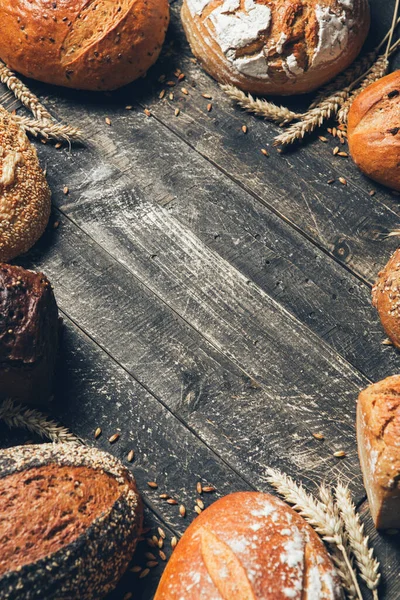 Borde de pan sobre fondo rústico de madera con espacio para copiar. Diferentes tipos de pan. Panadería, cocina y concepto de tienda de comestibles . — Foto de Stock