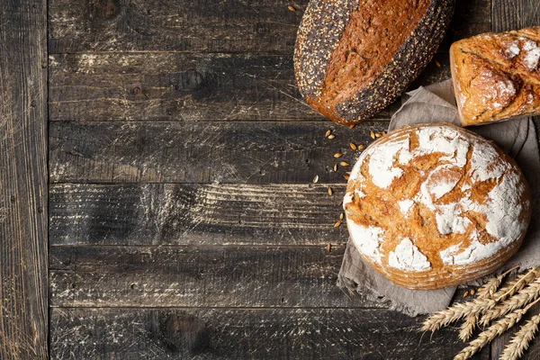 Borde de pan sobre fondo de madera con espacio para copiar. Diferentes tipos de pan en una esquina. Panadería, cocina y concepto de tienda de comestibles . — Foto de Stock