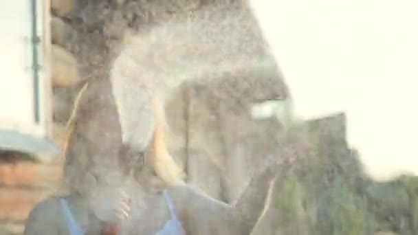 Молода жінка посипається від поливу банки — стокове відео