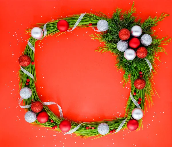 Natale cornice giocattoli di Natale e pini sullo sfondo rosso. — Foto Stock