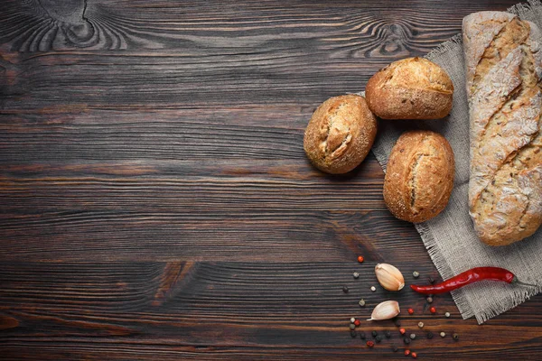 Ekmek, biber, sarımsak kahverengi ahşap tahta üzerinde bir dizi