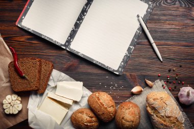 Petrol, ekmek, biber, sarımsak ve defter bir kahverengi ahşap tahta üzerinde bir dizi