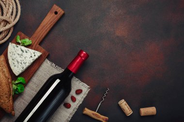 Şişe şarap, mavi peynir, badem, tirbuşon, ip ve paslı arka plan üstten görünüm tarihinde mantarlar