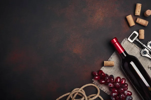 Şişe şarap, kırmızı üzüm, tirbuşon ve paslı arka plan üstten görünüm, kopya alanı tarihinde mantarlar