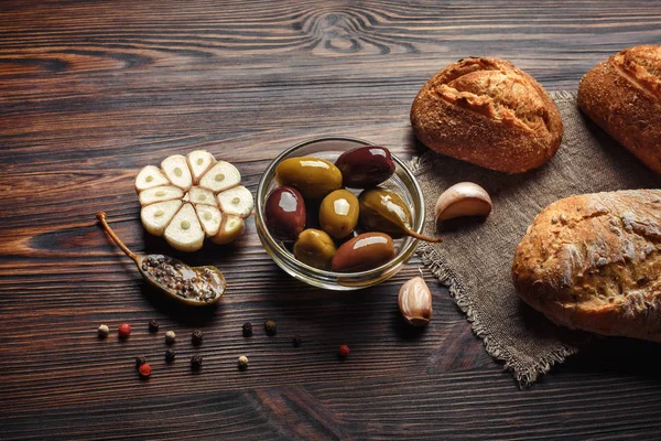 Sarımsak zeytin biber sarımsak kahverengi ahşap bir masa üzerinde bir dizi