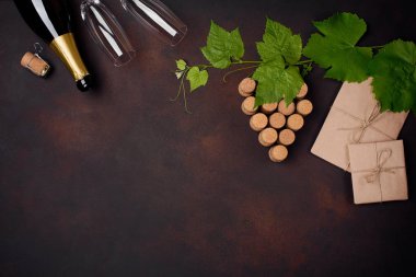 Şişe şampanya, üzüm demet paslı arka plan üstten görünüm yapraklarda mantar.