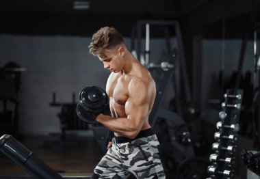 Halter salonunda ile atlet kaslı vücut geliştirmeci eğitim pazı kıvırmak.