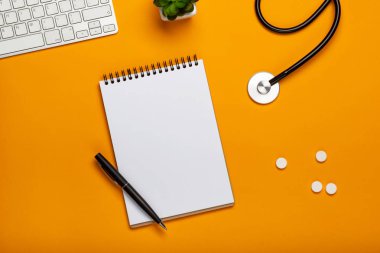 Doktor Resepsiyon stetoskop klavye Not defteri ve kalem, reçete ve senin metin için yer haplarla üstten görünüm.