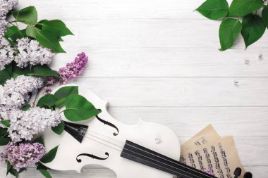 A bouquet of lilacs with violin and music sheet on a white wooden table. Top wiev with space for your text. clipart
