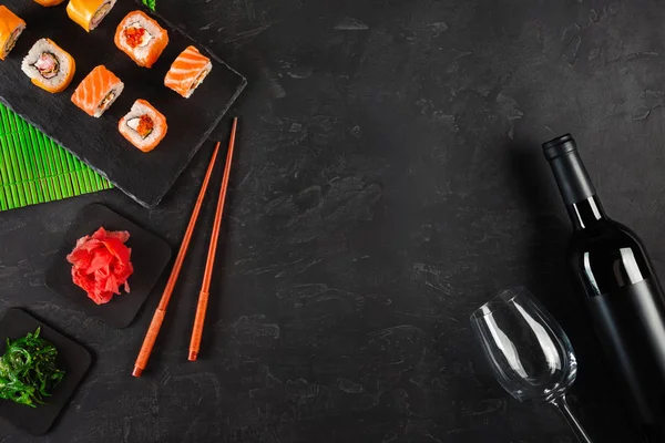Suşi Set sashimi ve suşi rulo, şişe şarap ve bir cam taş Kayrak servis.