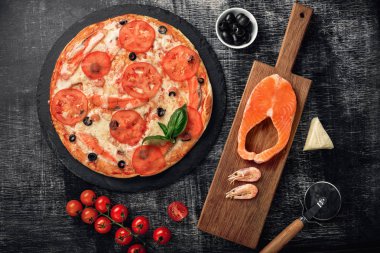 Pizza peyniri, alabalık, kiraz domates, zeytin ve karides tebeşir yönetim kurulu, üstten görünüm.