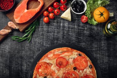 Pizza peyniri, alabalık, domates, zeytin ve karides tebeşir yönetim kurulu, üstten görünüm.