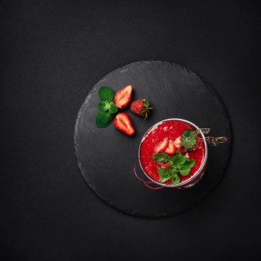 Çilekli tatlı mousse krema, karamel ve nane taş ve siyah arka plan ile. Üstten görünüm.