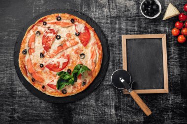 Pizza peyniri, alabalık, domates, zeytin ve karides bir taş ve bir siyah tebeşir yönetim kurulu, metin, en iyi görünüm için yer.