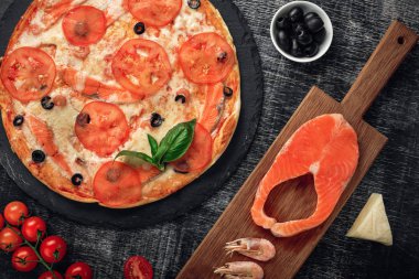 Pizza peyniri, alabalık, domates, zeytin ve karides tebeşir yönetim kurulu, üstten görünüm.