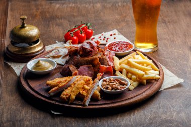 Bira ya da alkol ve içeriği için Füme domuz eti, patates kızartması, aperatifler büyük dizi ekmek, yengeç sopa ve ahşap arka plan üzerinde soslar ile servis fındık kızarmış.