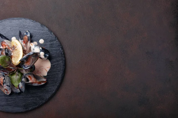 海鲜贻贝在奶油酱与柠檬和罗勒在石头和生锈的背景 带文本空间的顶部视图 — 图库照片