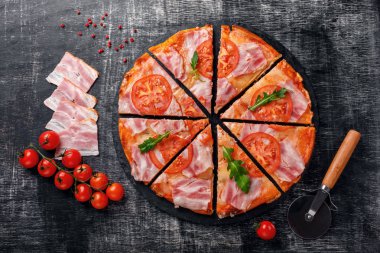 Geleneksel İtalyan pizza mozzarella peyniri, salam, domates, biber, baharat biber ve taze rucola bir taş ve bir siyah tebeşir tahtası çizilmiş. Üstten görünüm.