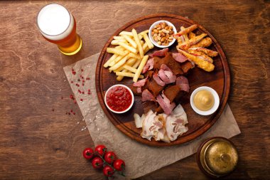 Bira ya da alkol ve içeriği için Füme domuz eti, patates kızartması, aperatifler büyük dizi ekmek, yengeç sopa ve ahşap arka plan üzerinde soslar ile servis fındık kızarmış. Üstten görünüm.