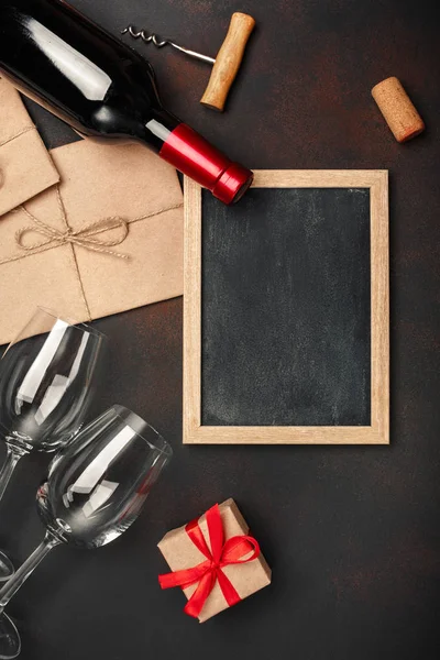 Şişe şarap, iki bardak, kara tahta, tirbuşon ve paslı arka plan üstten görünüm tarihinde mantarlar.
