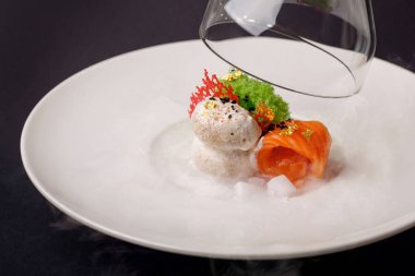 Moleküler modern mutfağı gravlax alabalık sarımsak dondurma siyah bir arka plan ile.