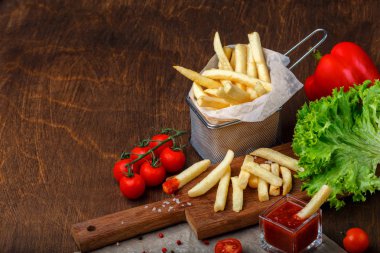 Ketçap, salata ve domates ahşap kahverengi masa üzerinde bir kılavuzda patates kızartması. Üstten görünüm.