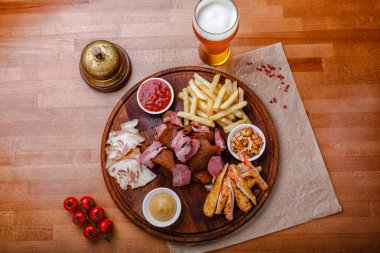 Bira ya da alkol ve içeriği için Füme domuz eti, patates kızartması, aperatifler büyük dizi ekmek, yengeç sopa ve ahşap arka plan üzerinde soslar ile servis fındık kızarmış. Üstten görünüm.