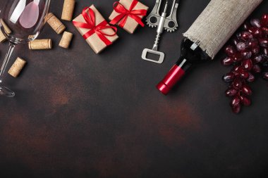 Şişe şarap, hediye kutusu, kırmızı üzüm, tirbuşon ve paslı arka plan üstten görünüm tarihinde mantarlar