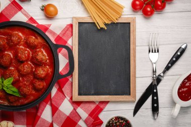 Domates soslu köfte kızartma tavası ve kiraz domates Beyaz ahşap tahta üzerinde içinde baharatlar ile. Metin alanı olan üstten görünüm.