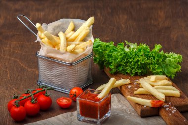 Ketçap, salata ve domates ahşap kahverengi masa üzerinde bir kılavuzda patates kızartması. Üstten görünüm.