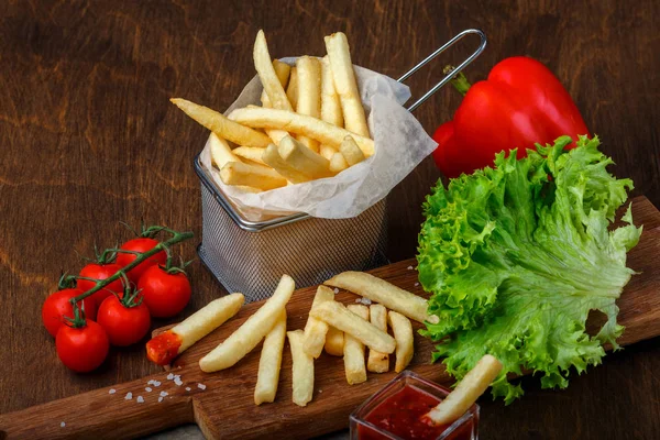 Ketçap, salata ve domates ahşap kahverengi masa üzerinde bir kılavuzda patates kızartması. Üstten görünüm.