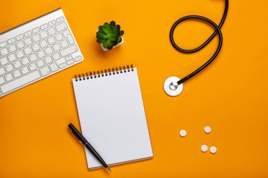 Doktor Resepsiyon stetoskop klavye Not defteri ve kalem, reçete ve senin metin için yer haplarla üstten görünüm.