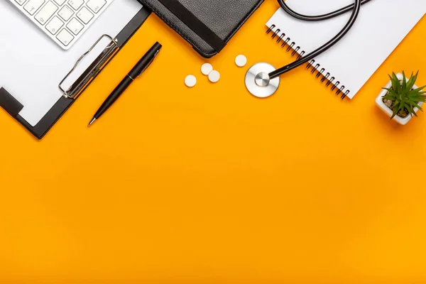 Doktor Resepsiyon stetoskop klavye Not defteri ve kalem, reçete ve senin metin için yer haplarla üstten görünüm.