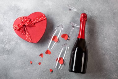 Bir şişe şampanya, bir kalp şeklinde çikolata bir kutu ile gözlük ile Sevgililer günü kartı. Kutlama için alanı olan üstten görünüm.