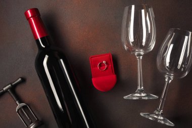 Bir şişe şarap ve bir bardak ve bir nişan yüzüğü ile Sevgililer günü. Kopya alanı ile üstten görünüm.