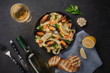 Deniz ürünleri ve taş masada beyaz şarap ile makarna. Midye ve karides. Üstten Görünüm