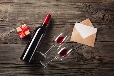 Sevgililer günü tebrik kartı. Kırmızı şarap, hediye kutusu ve ahşap masa gözlük. Selam yeri olan görüntülemek