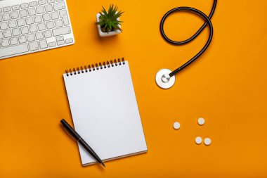 Doktor Resepsiyon stetoskop klavye Not defteri ve kalem, reçete ve senin metin için yer haplarla üstten görünüm.
