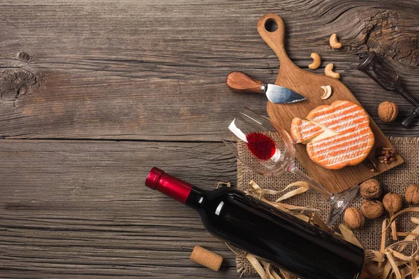 Holiday Dinner setting with red wine and creaming cheese on rustic wood. Top view with space for your greetings