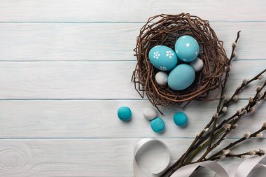 Yuva ve Kukum mavi boyalı yumurtalar. Paskalya tebrik kartı. Selam yeri olan üstten görünüm.