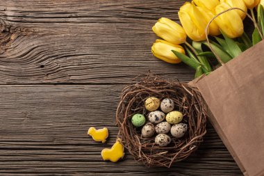 Paskalya gingerbread çerezleri ahşap masa ve sarı laleler. Tebrik kartı. Kopya alanı ile üstten görünüm.