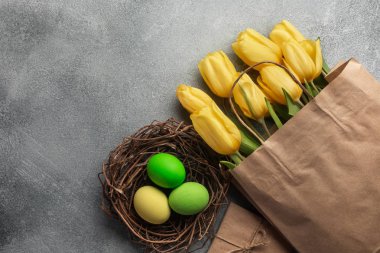 Paskalya renkli yumurta ve taş Gri Sarı laleler arka plan. Kopya alanı ile Üstten Görünüm