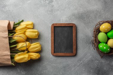 Paskalya renkli yumurta ve taş Gri Sarı laleler arka plan. Kopya alanı ile Üstten Görünüm