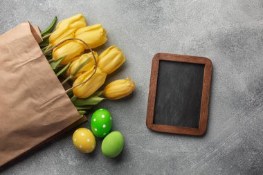 Paskalya renkli yumurta ve taş Gri Sarı laleler arka plan. Kopya alanı ile Üstten Görünüm