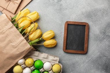 Paskalya renkli yumurta ve taş Gri Sarı laleler arka plan. Kopya alanı ile Üstten Görünüm